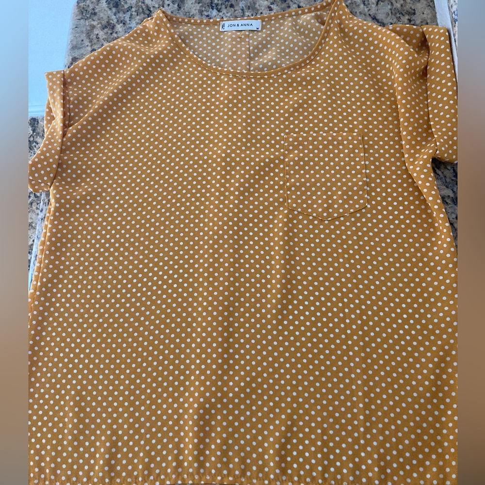 Yellow with white polka dots and button up closure in back. Size medium.